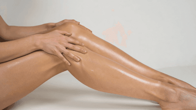 Hands applying lotion to smooth legs