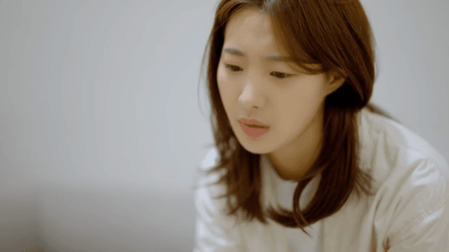 소파에 앉아 초조하게 무언가를 기다리는 여성