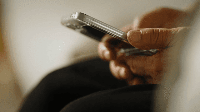 Hands holding a smartphone indoors