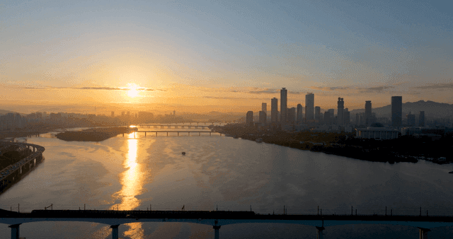 도시 스카이라인과 강 위의 일출