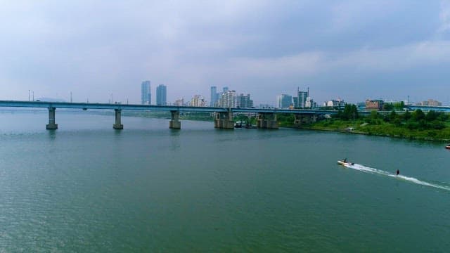 Speedboat Navigating River by Urban Landscape