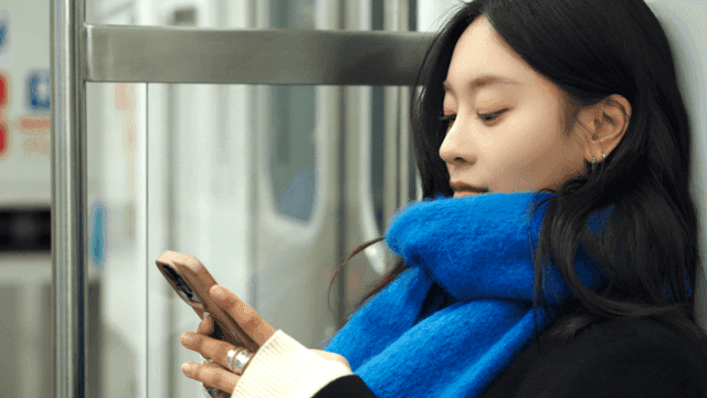 Profile of a woman using her smartphone on the subway