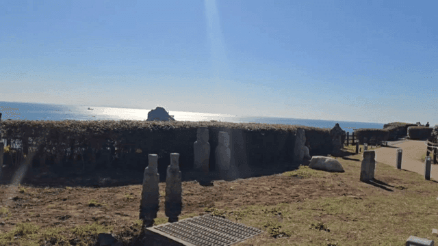 돌 조각상과 바다가 보이는 해안 풍경