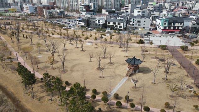 Park with a traditional pavilion near a city