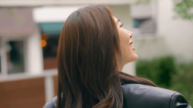 집을 나서며 미소 짓고 인사하는 여성