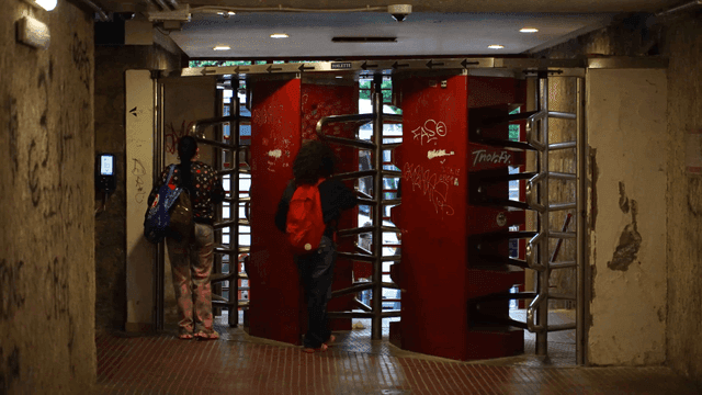 People passing through a turnstile in a subway