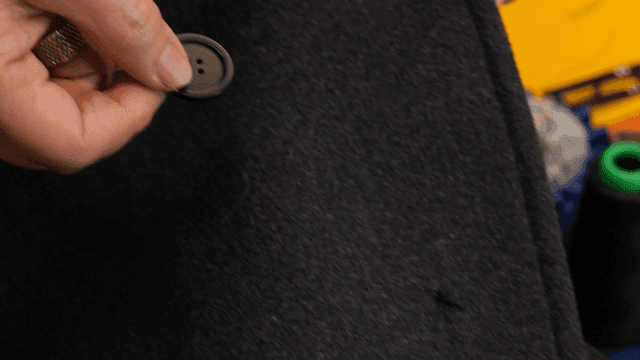Hand holding button on fallen coat