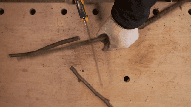 나무 작업대에서 가지를 자르는 톱