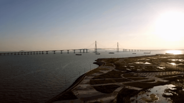 Long bridge over a calm sea at sunset
