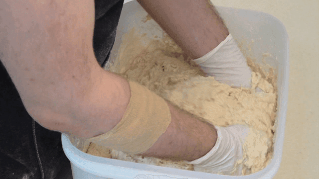 Mixing batter in a large bowl by baker