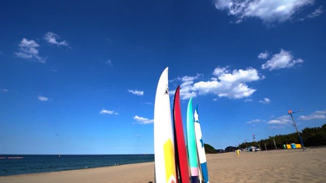 Beach with volleyball net and surfboard under clear sky