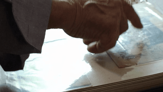 Old man's hand pointing to a photo album