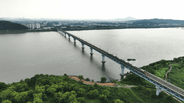 Train crossing a long bridge over a river