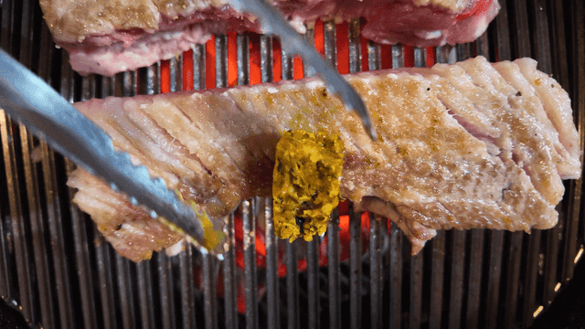 Butter on top of pork belly on grill