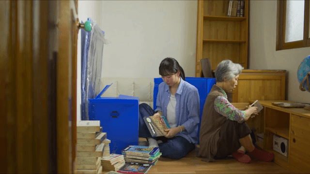 woman and elderly woman organizing books in a room