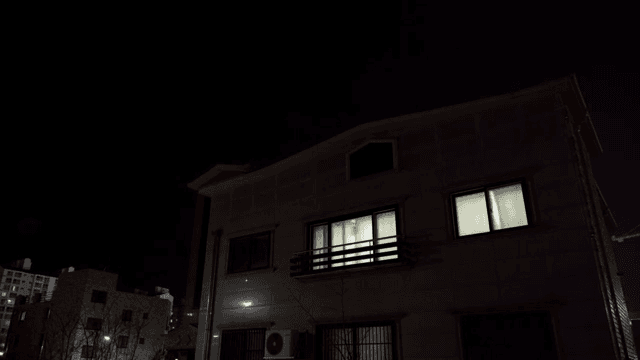 밤에 불이 켜진 창문이 있는 주택