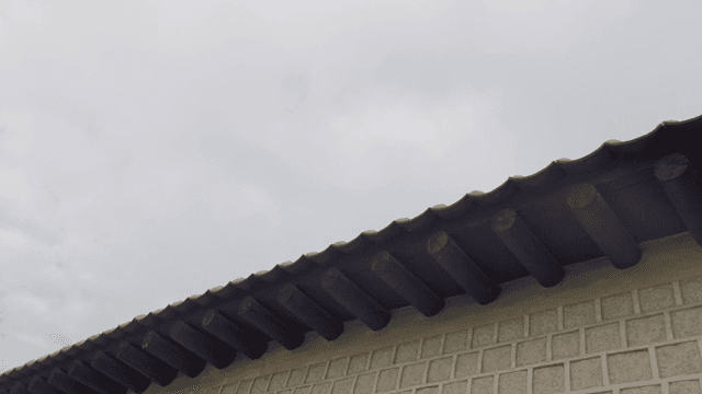 Traditional Korean house roof under cloudy sky