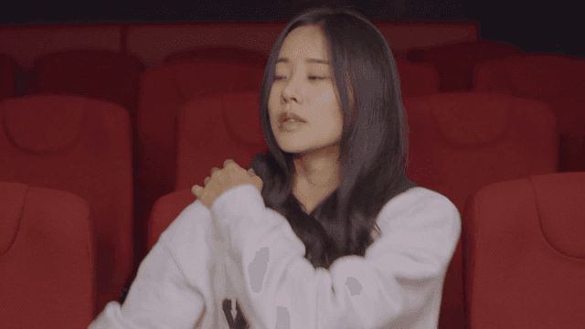 극장에서 혼자 앉아 있다 일어서는 여성