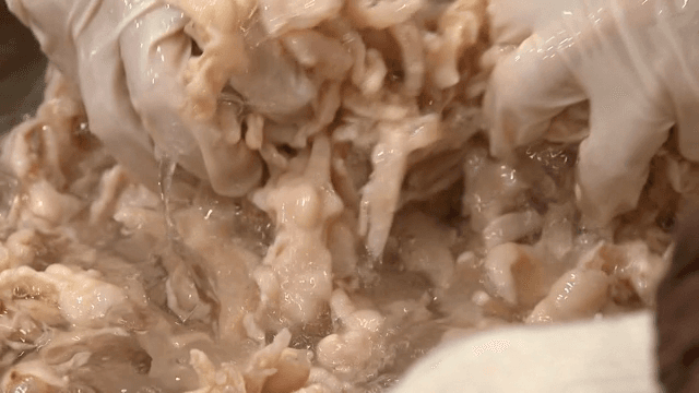 얼음물 안에 있는 생닭발을 손으로 섞기