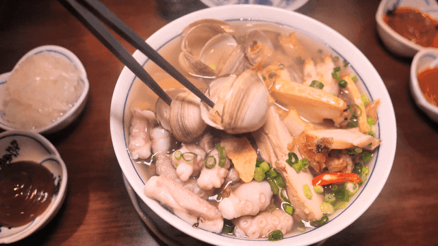 Chopsticks for mixing nourishing seafood rice noodles with clams and octopus