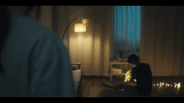 Man decorating a tree in a dark room