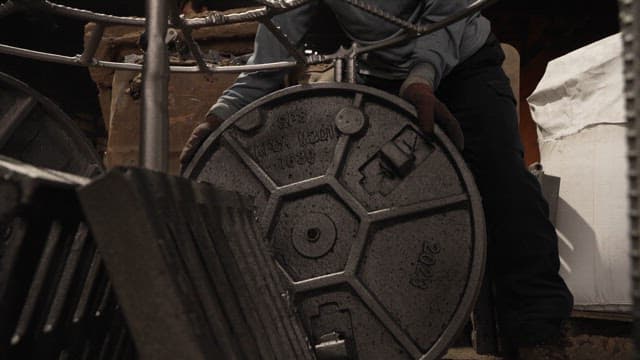 Worker handling a large metal cover