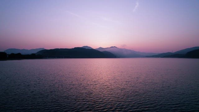 Tranquil Sunset Over Calm Lake With Mountains