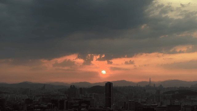 구름이 있는 도시 스카이라인 위의 일출