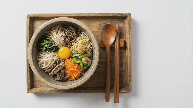 Bowl of stone pot bibimbap filled with various vegetables