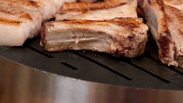 Grilling pork belly on a hot grill