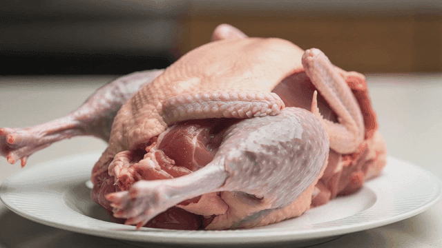 Raw chicken placed on a white plate