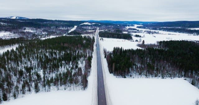 Snow-covered landscape with a long road