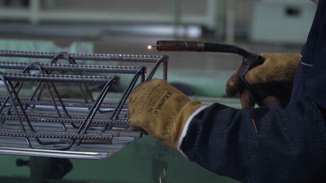 Worker welding metal structures in a factory