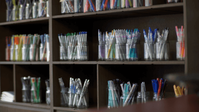 다양한 펜들이 담긴 병들이 있는 선반