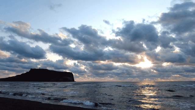 Tranquil beach sunset with waves and clouds