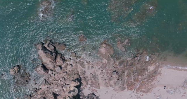 화창한 날의 암석이 많은 모래 해변