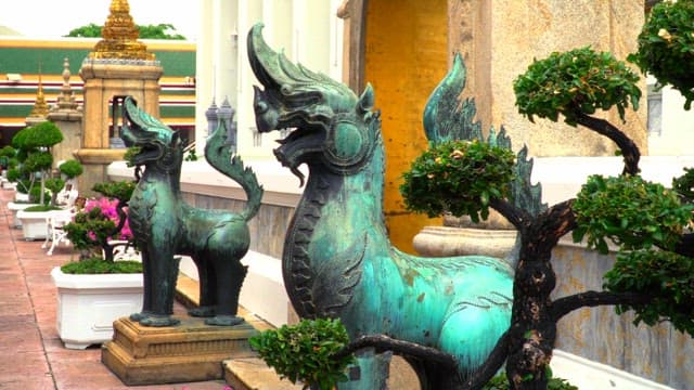 Bronze statues guarding the garden of a Thai temple