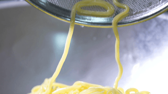 Freshly cooked noodles in a strainer