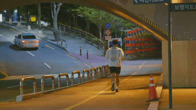 밤에 다리 아래에서 조깅하는 남자
