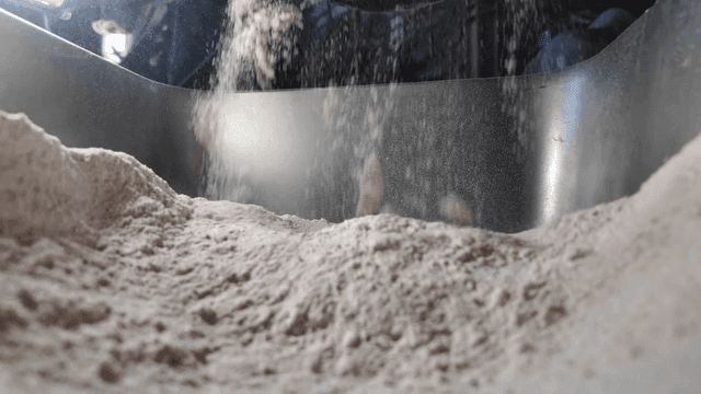 Flour pouring out of large mixer