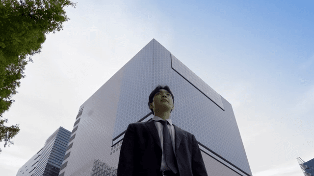 Office worker standing in front of a tall building