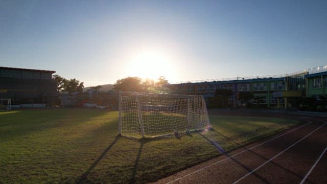 일출에 축구 골대가 있는 학교 운동장