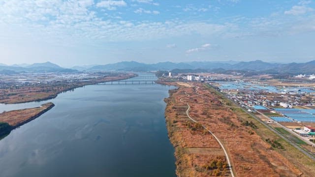 Serene river flowing beside farmland and mountains