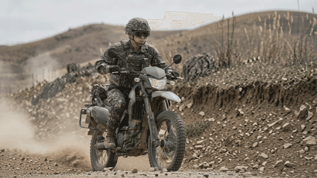 Soldier riding motorcycle on dusty road