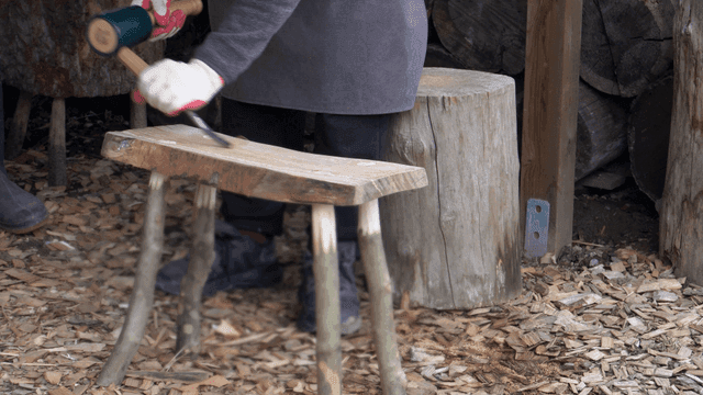 야외에서 나무 의자를 만드는 사람