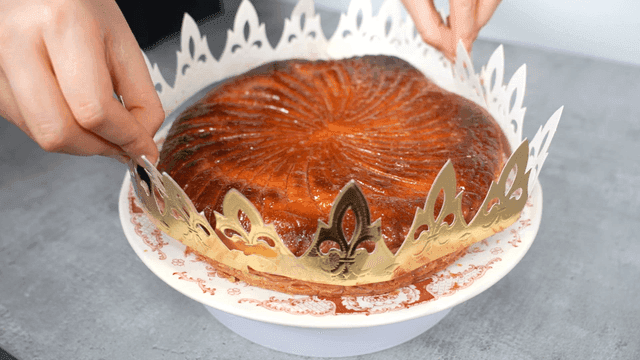 Hands placing crown on round cake