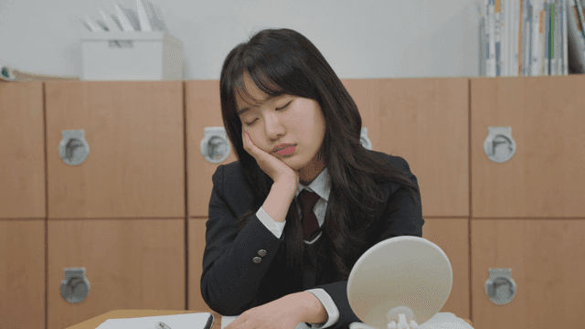Student in a classroom looking tired