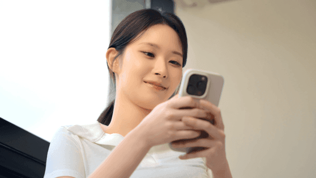 실내에서 스마트폰을 사용하는 여성