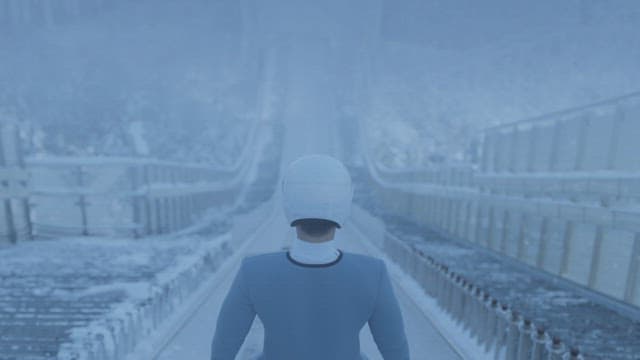 눈 속에서 슬로프를 내려오는 스키 점프 선수