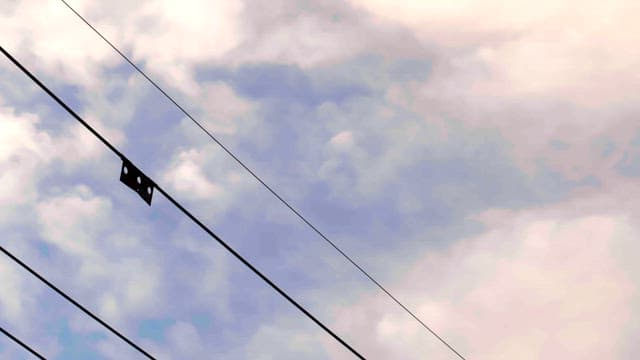 구름이 가득한 하늘 위로 뻗어 있는 전선들